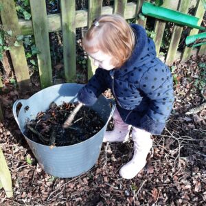 student using a bucket of woodchip