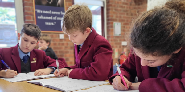 students writing out onto booklets